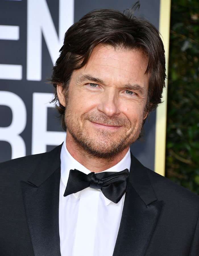 Jason Bateman smiling in a black tuxedo at a formal event, raising eyebrows with a remark about sister Justine. Jason Bateman smiling in a black tuxedo at a formal event, raising eyebrows with a remark about sister Justine.
