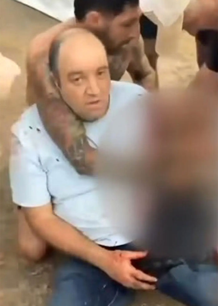 Man at Bondi Beach being restrained by a hero disarming attacker during Hanukkah event, capturing a stunning act. Man at Bondi Beach being restrained by a hero disarming attacker during Hanukkah event, capturing a stunning act.