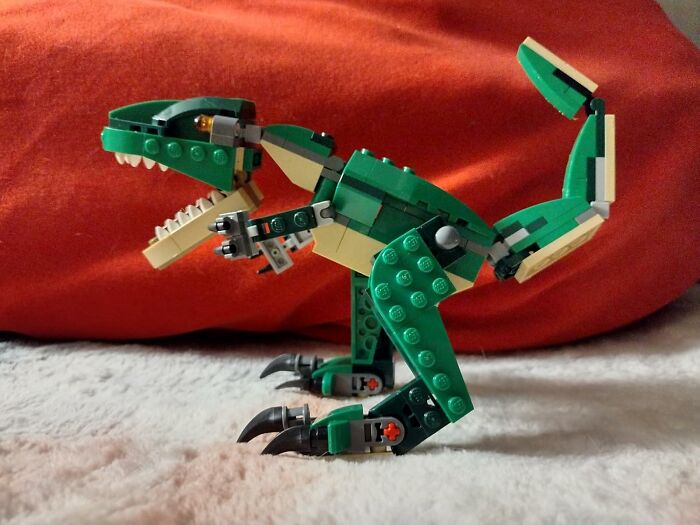 Green LEGO dinosaur toy with articulated limbs and claws, featured among best sellers in 2025 delusional trends.