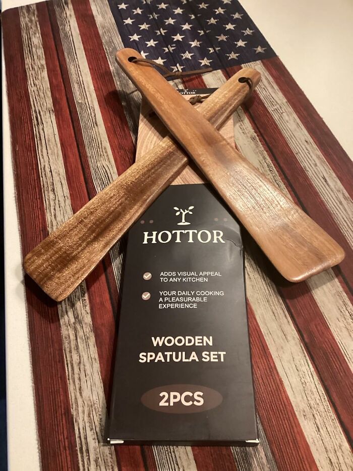 Wooden spatula set on rustic American flag cloth, ideal host gifts showing appreciation beyond typical wine bottles.