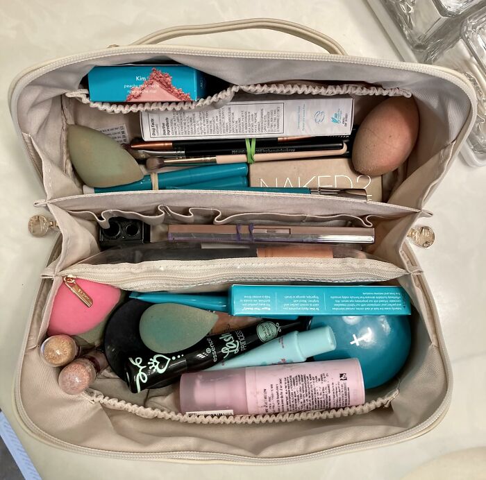 Makeup bag filled with popular Amazon wish list products including beauty blenders, brushes, and cosmetics.