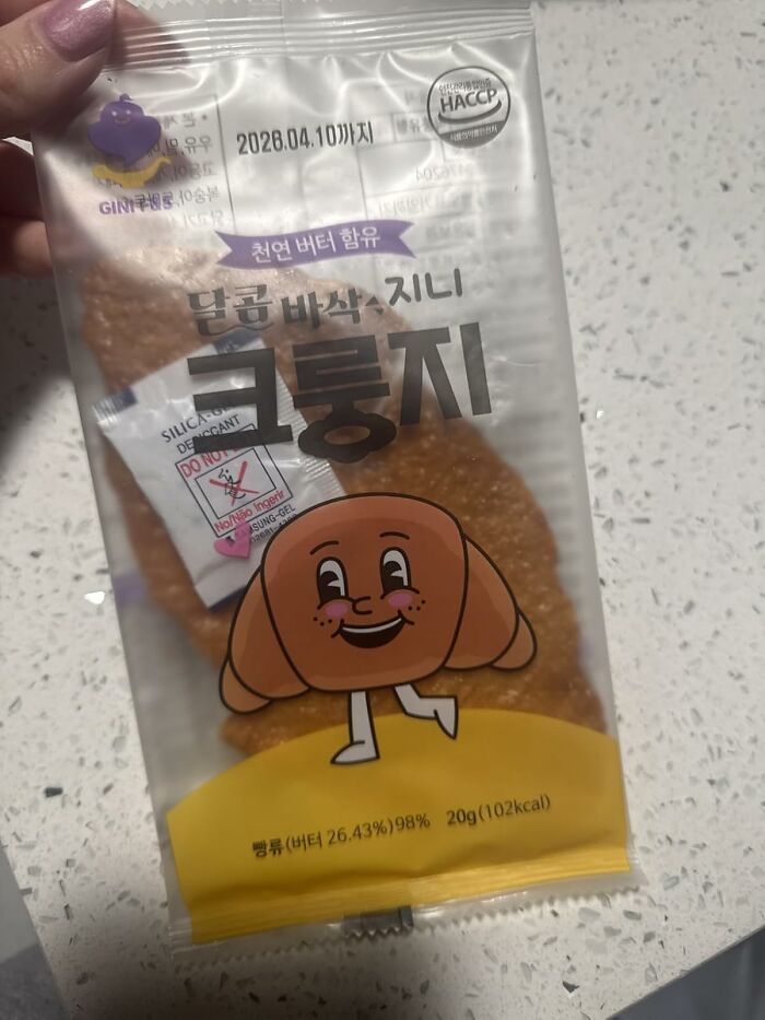 Package of wacky foods snack with smiling croissant cartoon, perfect gift for your snack-obsessed friend holding it.