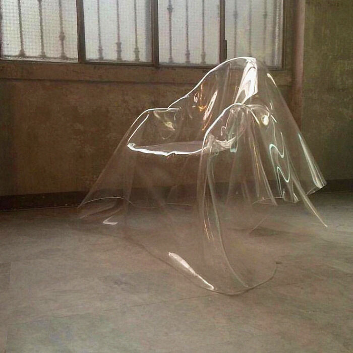 Transparent chair covered with a clear plastic sheet in a minimalist room, a trippy picture from another reality.