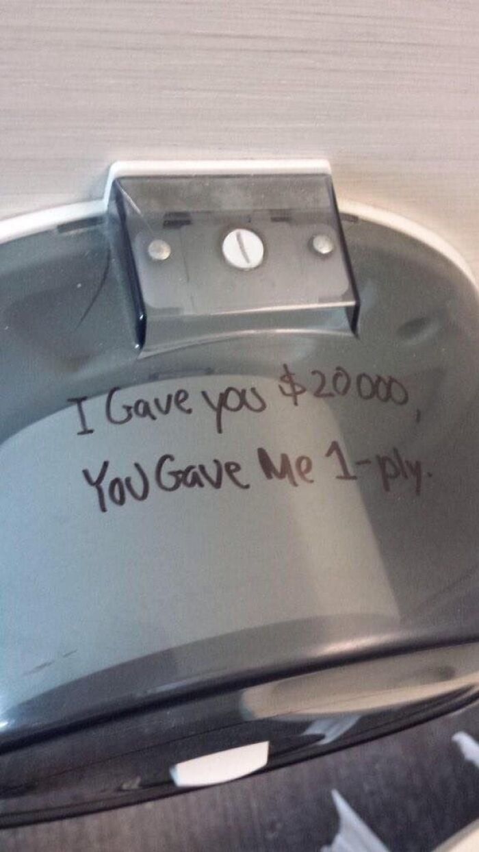 Toilet paper dispenser with humorous handwritten message referencing a $20,000 bribe for just one-ply paper in a random funny pic.