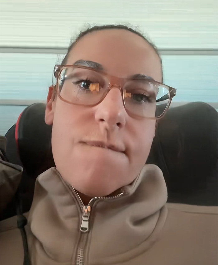 Woman with glasses and beige jacket expressing frustration on an Air Canada flight about an expired meal issue. Woman with glasses and beige jacket expressing frustration on an Air Canada flight about an expired meal issue.