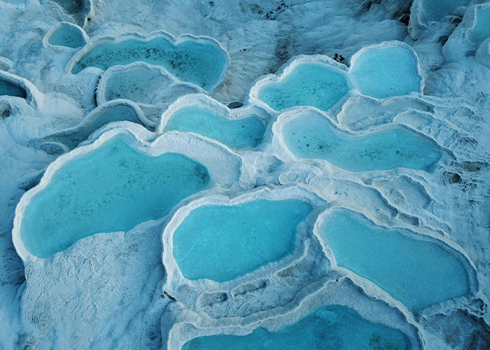 Terraced natural pools with vibrant blue water, a stunning place from around the world that looks AI generated but is real.