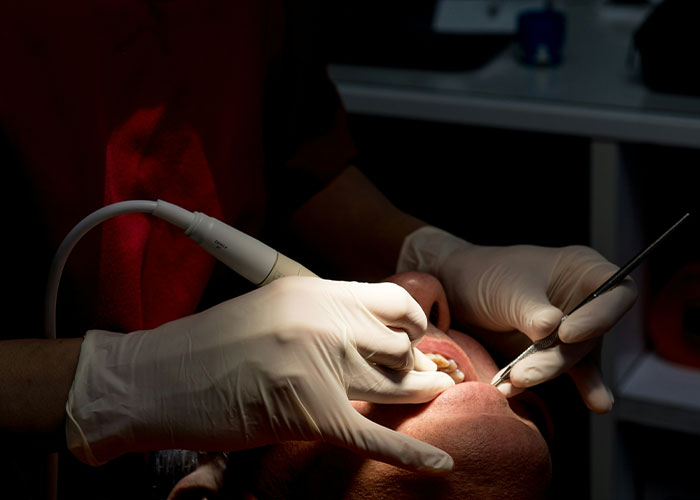 Patient in dentist chair receiving a dental procedure, highlighting a haunting final moment before a fatal outcome.