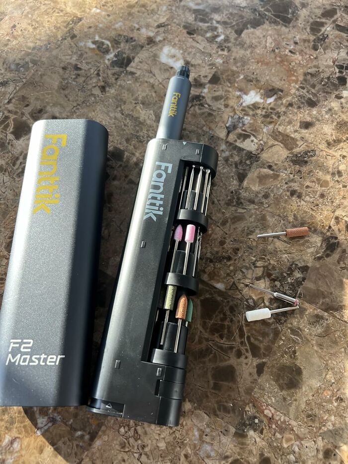 Portable electric nail drill kit with various attachments on a marble surface, a popular Amazon wish list product.