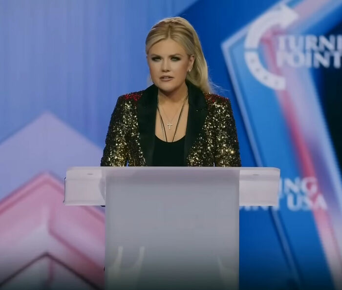 Erika Kirk speaking at TPUSA event, wearing a black and gold jacket during the greatest Freudian slip moment. Erika Kirk speaking at TPUSA event, wearing a black and gold jacket during the greatest Freudian slip moment.
