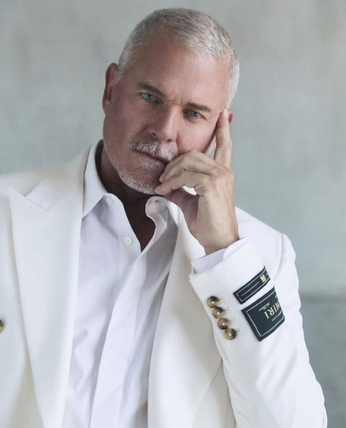 Eric Dane in a white blazer posing thoughtfully, representing celebrities with rare conditions and their hidden realities.