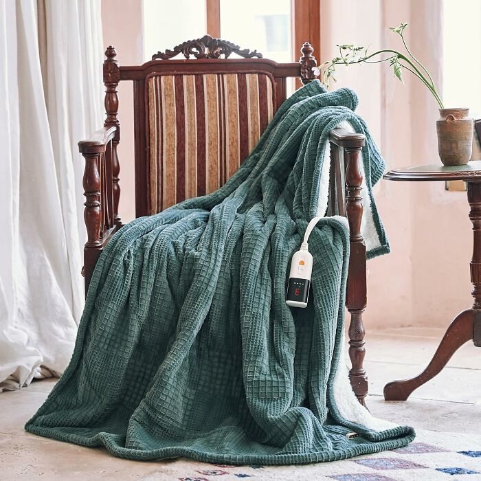 Heated blanket draped over vintage wooden chair, a cozy gift idea for the person who has everything.