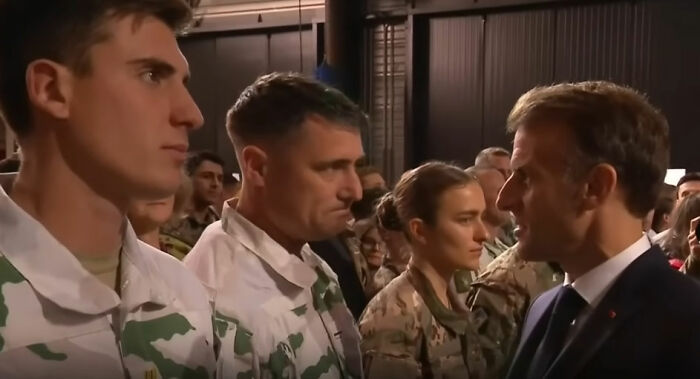 French soldier displaying odd behavior behind Macron during a tense moment sparking France is boiling conspiracy theories.