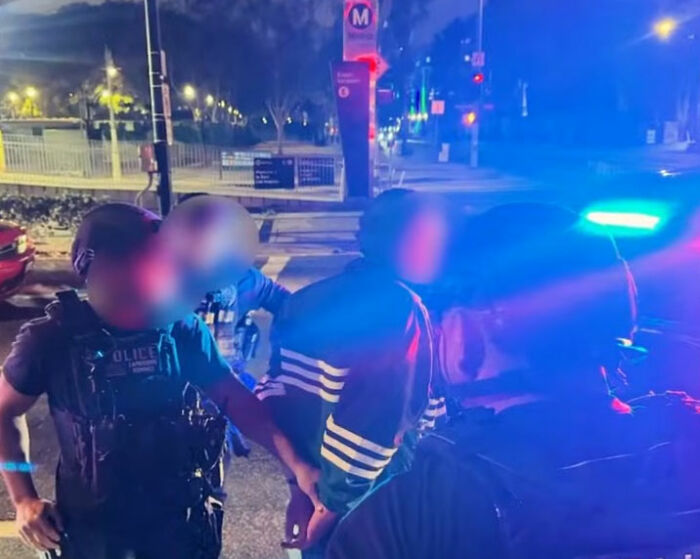 Police arresting a suspect at night near a police car with flashing lights in connection to Nick Reiner's hotel room case. Police arresting a suspect at night near a police car with flashing lights in connection to Nick Reiner's hotel room case.