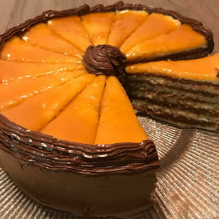 Layered Christmas dessert cake with orange glaze and chocolate frosting, showcasing delicious-looking holiday treats from around the world