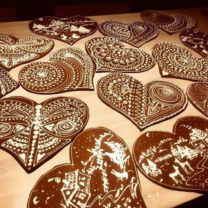 Heart-shaped Christmas desserts from around the world decorated with intricate white icing patterns on gingerbread cookies.
