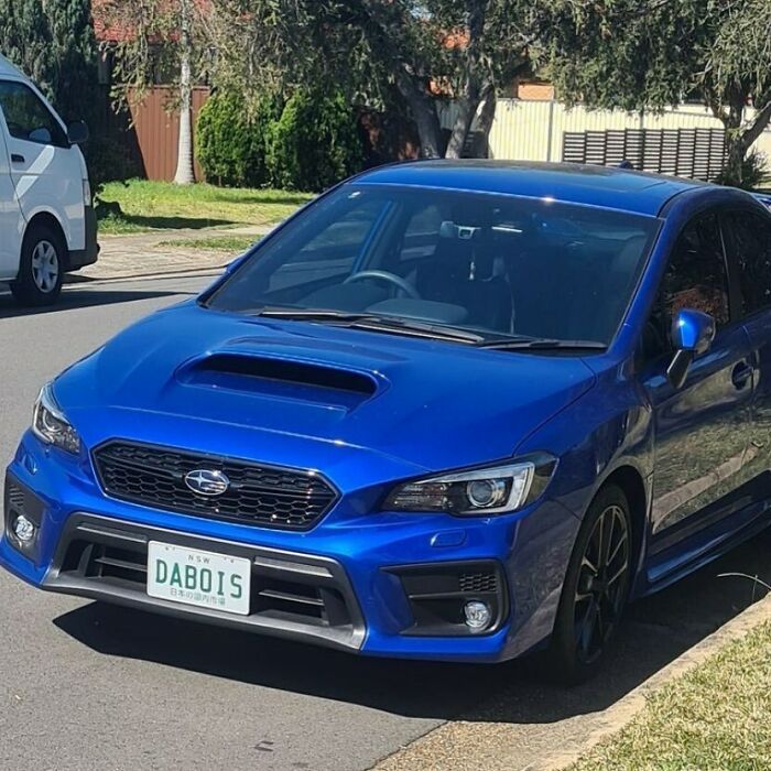 Blue Subaru parked on the street with a personalized license plate reading DABOIS, showcasing hilarious personalized license plates.