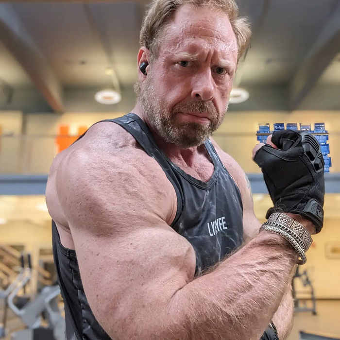 Muscular man in gym flexing bicep wearing black tank top and glove, illustrating scarier than Terminator concept. Muscular man in gym flexing bicep wearing black tank top and glove, illustrating scarier than Terminator concept.