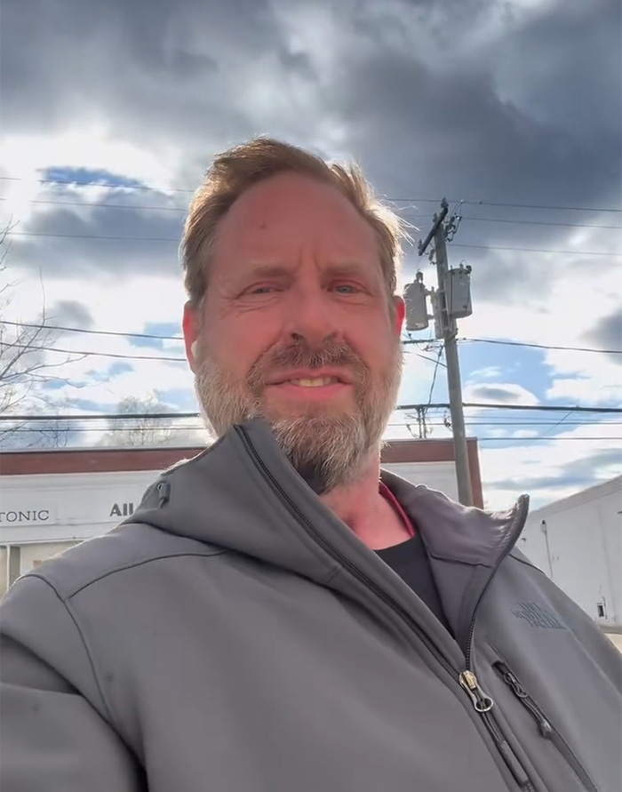Middle-aged man with beard wearing a gray jacket standing outdoors under a cloudy sky, discussing ChatGPT controversy. Middle-aged man with beard wearing a gray jacket standing outdoors under a cloudy sky, discussing ChatGPT controversy.
