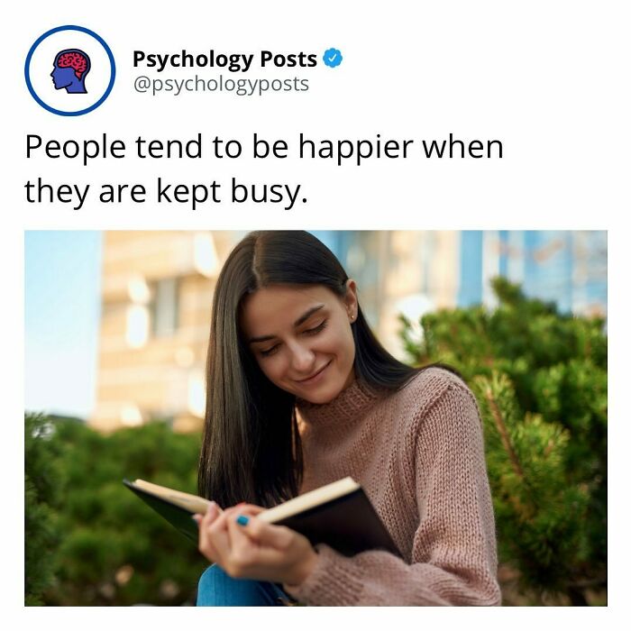 Young woman reading a book outdoors, illustrating psychology facts about happiness and staying busy in everyday life.