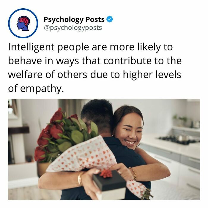Couple hugging with flowers and gift in kitchen, illustrating empathy and psychology facts about intelligent behavior.