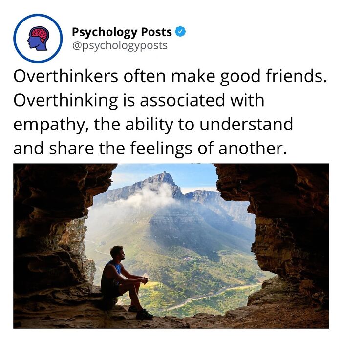Person sitting inside cave opening overlooking mountain landscape, illustrating psychology facts about overthinking and empathy.