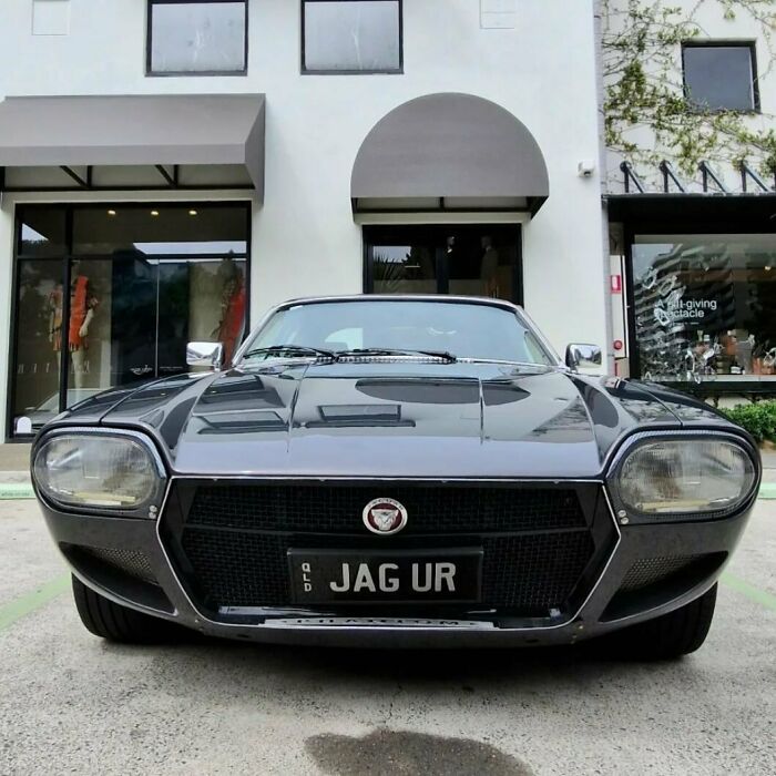 Classic black sports car with a personalized license plate reading JAG UR, showcasing hilarious personalized license plates.