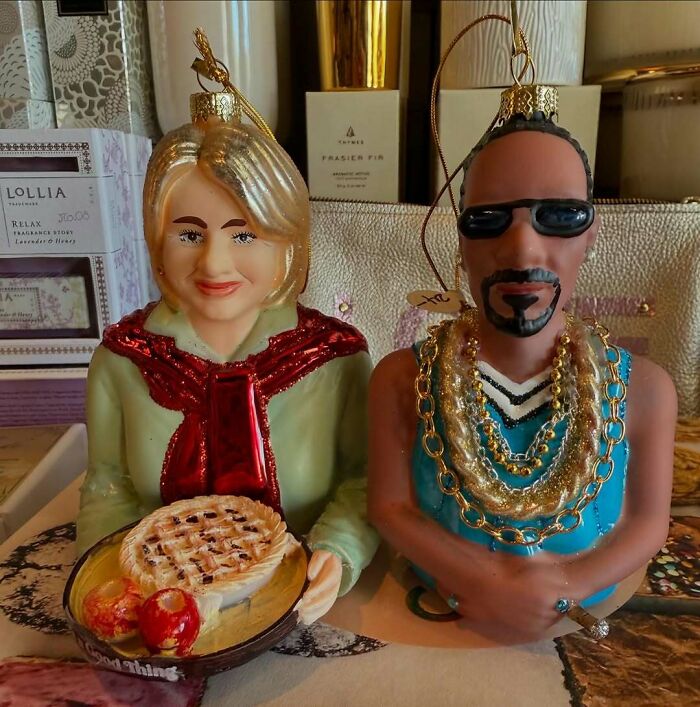 Two bizarre Christmas gift ornaments, one holding a pie and the other wearing gold chains and sunglasses.