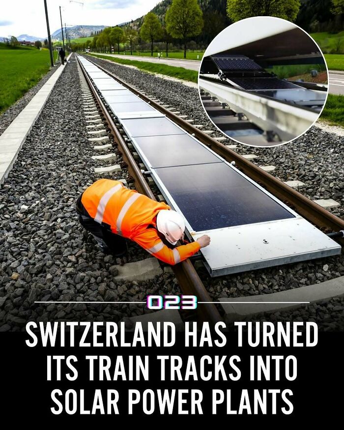 Worker in safety gear inspecting solar panels integrated into train tracks, showcasing positivity recommended innovation in renewable energy.