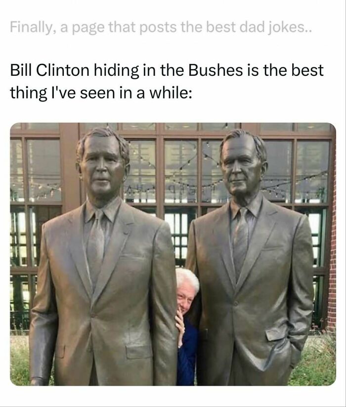 Bill Clinton playfully hiding between two statues of men in suits, a visual dad joke from a dad jokes account.