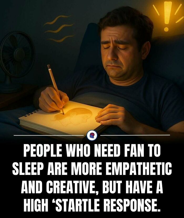 Man drawing a portrait in bed with a fan running, illustrating psychology facts about empathy, creativity, and startle response.