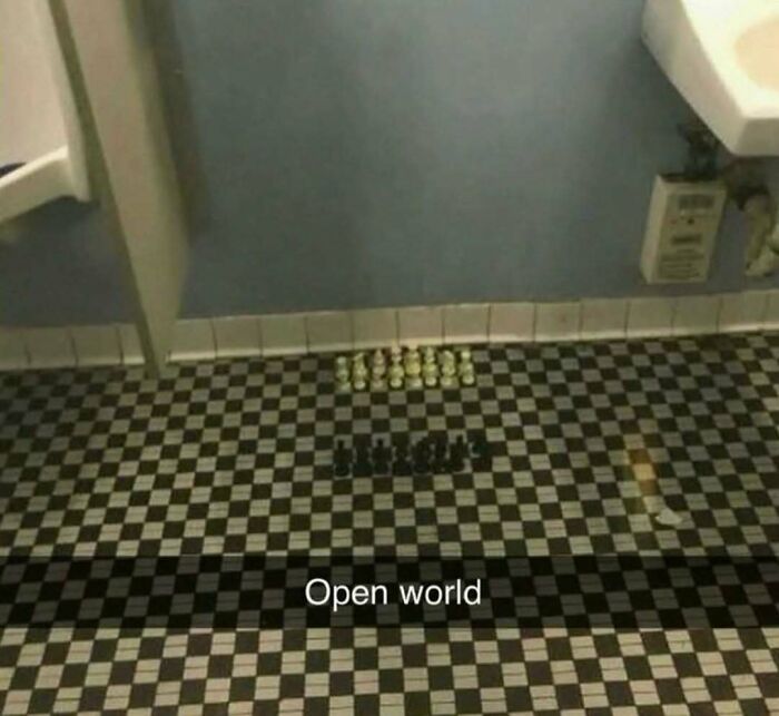 Small chess pieces arranged on a checkered bathroom floor with the caption open world, a funny Know Your Meme moment.