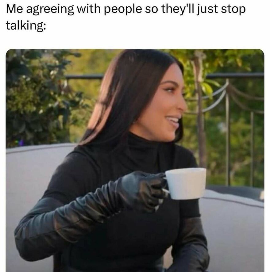 Woman in black outfit holding a white cup and smiling, illustrating a meme about therapy and agreeing with people to stop talking.