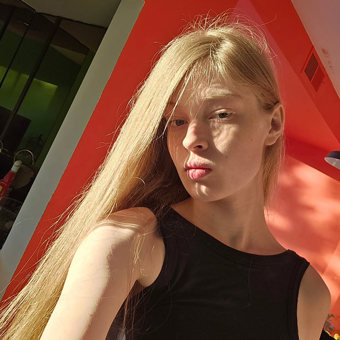 Young woman with long blonde hair in a black sleeveless top, highlighted by sunlight, representing tragic mental illness awareness. Young woman with long blonde hair in a black sleeveless top, highlighted by sunlight, representing tragic mental illness awareness.