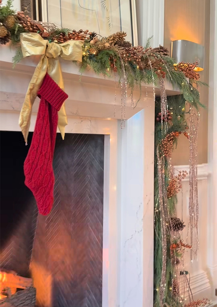 Christmas fireplace decorated with garland and red stocking, highlighting Jennifer Lopez fans noticing a depressing detail. Christmas fireplace decorated with garland and red stocking, highlighting Jennifer Lopez fans noticing a depressing detail.