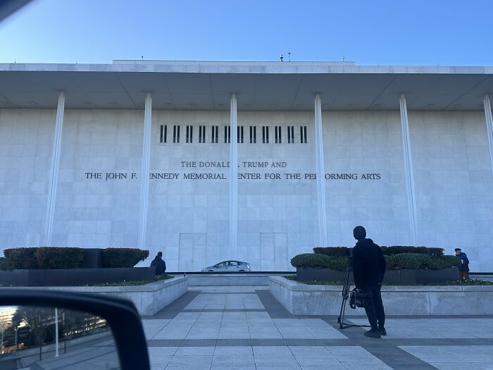 The Kennedy Center building exterior with people and cameras amid debates on Kennedy Center renaming controversy online.