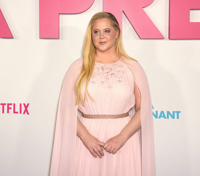 Amy Schumer posing in a pink dress at a Netflix event, showcasing dramatic weight loss and a confident look. Amy Schumer posing in a pink dress at a Netflix event, showcasing dramatic weight loss and a confident look.