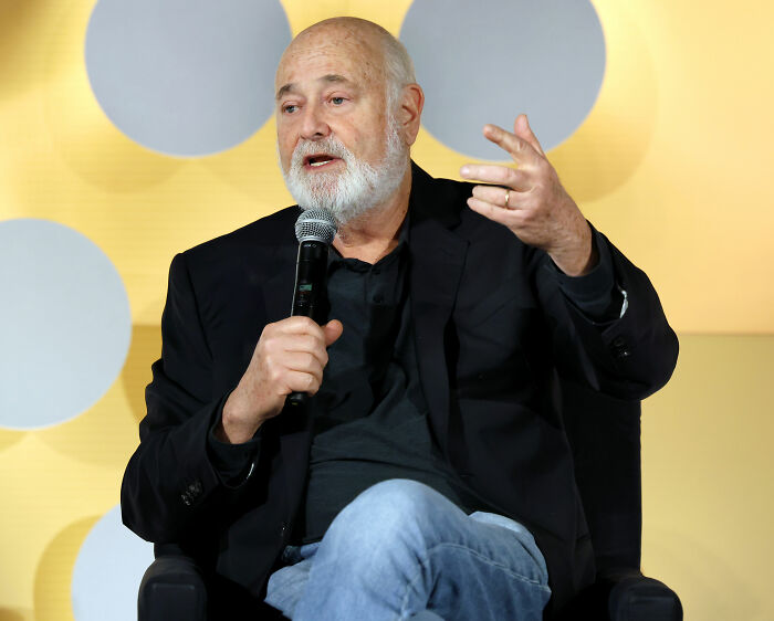 Rob Reiner speaking into a microphone, wearing a black jacket and jeans, discussing Donald Trump and hateful vile comments. Rob Reiner speaking into a microphone, wearing a black jacket and jeans, discussing Donald Trump and hateful vile comments.