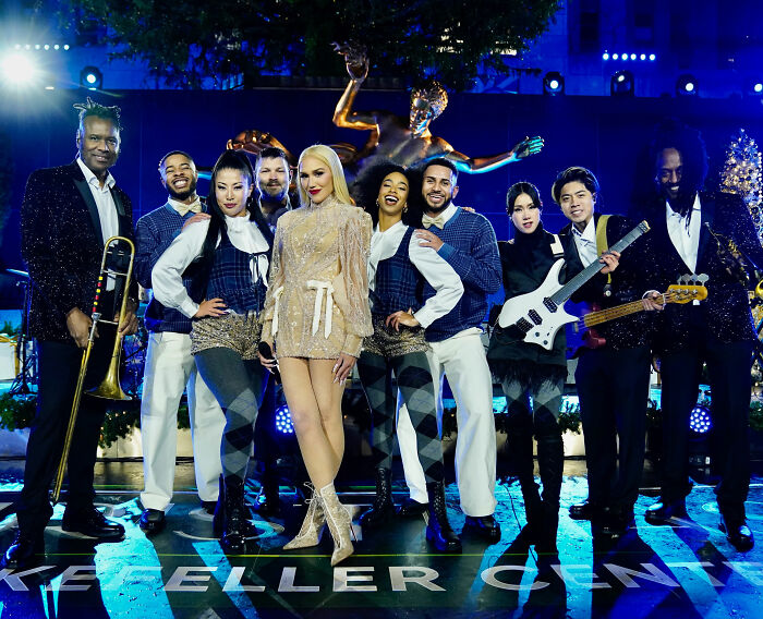 Gwen Stefani wearing a glittery outfit with her band at Rockefeller Center during the tree lighting event. Gwen Stefani wearing a glittery outfit with her band at Rockefeller Center during the tree lighting event.