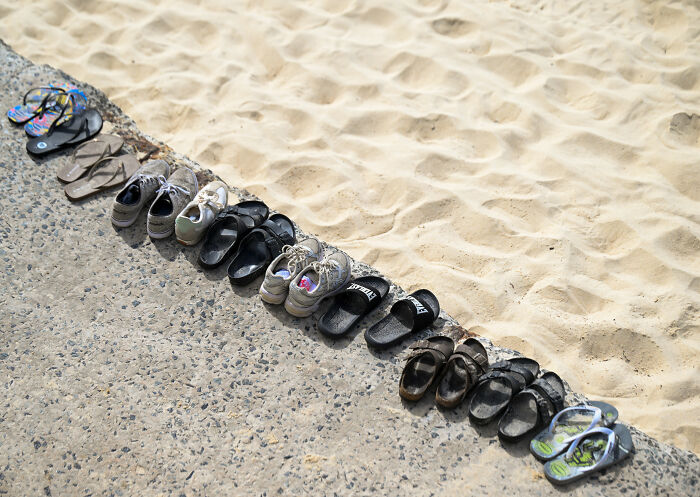 Various sandals and shoes neatly lined up along the edge of sandy beach, related to Bondi Beach attack GoFundMe controversy. Various sandals and shoes neatly lined up along the edge of sandy beach, related to Bondi Beach attack GoFundMe controversy.