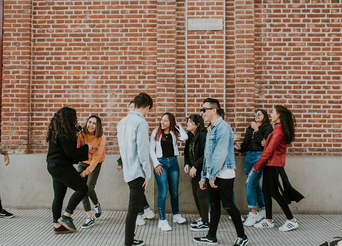 Group of young friends laughing and chatting outdoors, depicting emotions related to feeling betrayed and wanting space in friendship.
