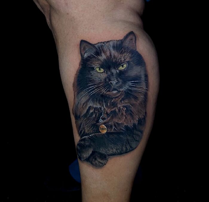 Realistic black cat tattoo on calf, a beautiful pet tribute capturing memories with detailed ink art.