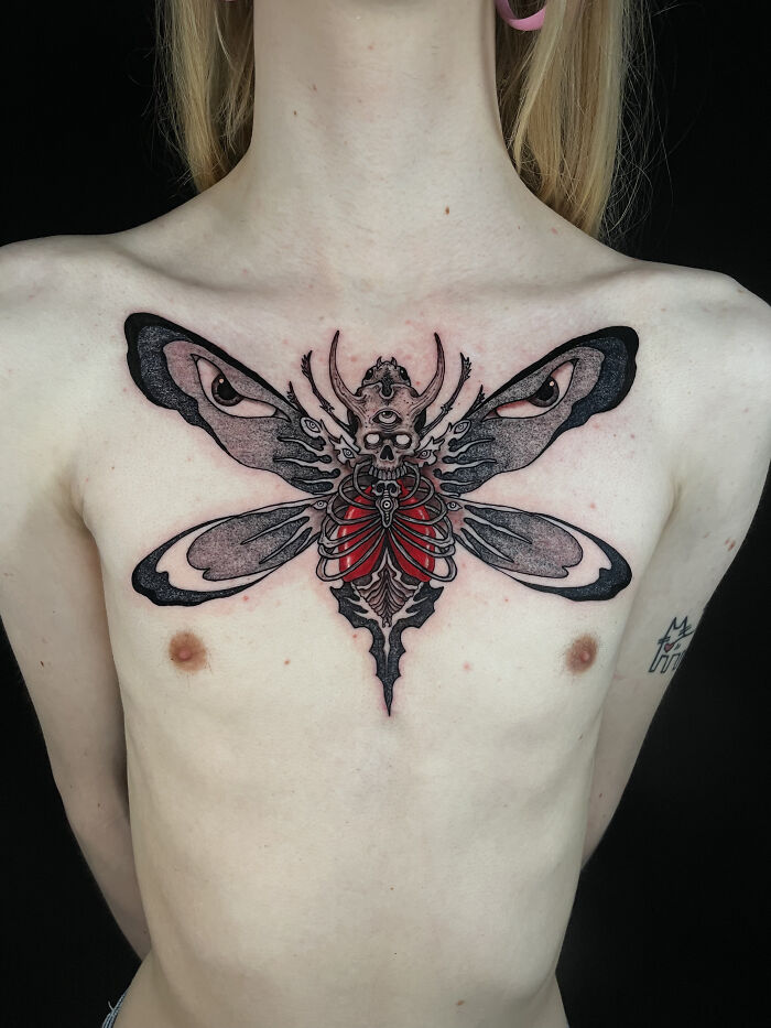 Chest tattoo of a surreal insect with eyes on its wings and skeletal red heart, showcasing psychedelic tattoos art style. Chest tattoo of a surreal insect with eyes on its wings and skeletal red heart, showcasing psychedelic tattoos art style.