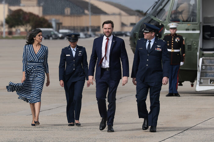 JD Vance walking with military personnel on tarmac, addressing marriage speculation after viral hug and bare finger details. JD Vance walking with military personnel on tarmac, addressing marriage speculation after viral hug and bare finger details.