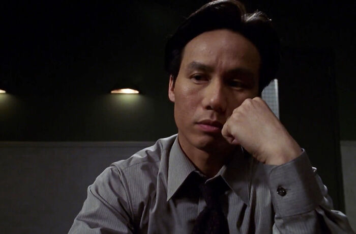 BD Wong from Jurassic World looks thoughtful and somber in a dimly lit room reflecting on his recent apology. BD Wong from Jurassic World looks thoughtful and somber in a dimly lit room reflecting on his recent apology.