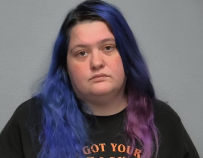 Woman with blue and purple hair wearing a black shirt, related to DoorDasher arrested for allegedly pepper-spraying food.