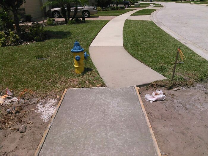 Poorly done sidewalk construction ending abruptly near fire hydrant, illustrating job failures that are almost impressive. Poorly done sidewalk construction ending abruptly near fire hydrant, illustrating job failures that are almost impressive.