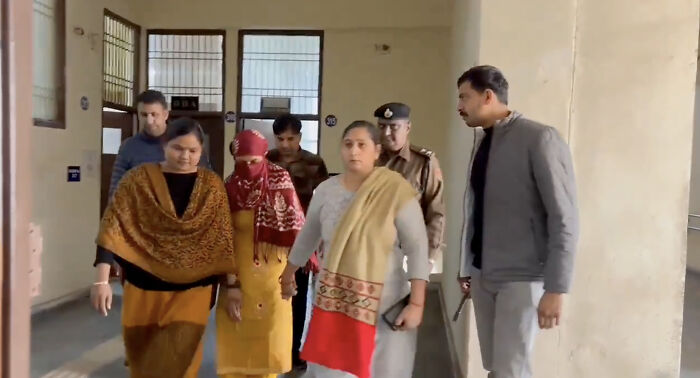 Family and police escort a woman suspected in a horrifying wedding tragedy after missing child's body discovery