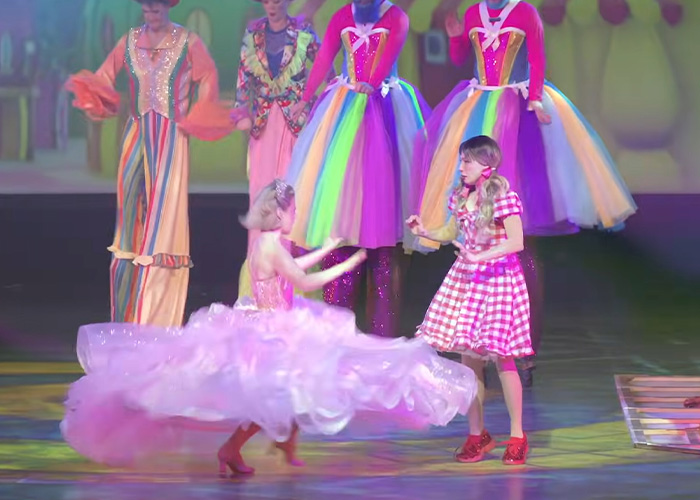 Actors in colorful costumes performing a Wizard Of Oz stage show with vibrant dresses and lively action on stage. Actors in colorful costumes performing a Wizard Of Oz stage show with vibrant dresses and lively action on stage.