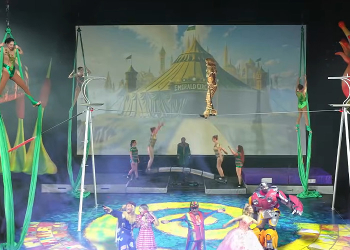 Stage performers in Wizard of Oz themed costumes during a circus act with aerial silks and tightrope walking. Stage performers in Wizard of Oz themed costumes during a circus act with aerial silks and tightrope walking.