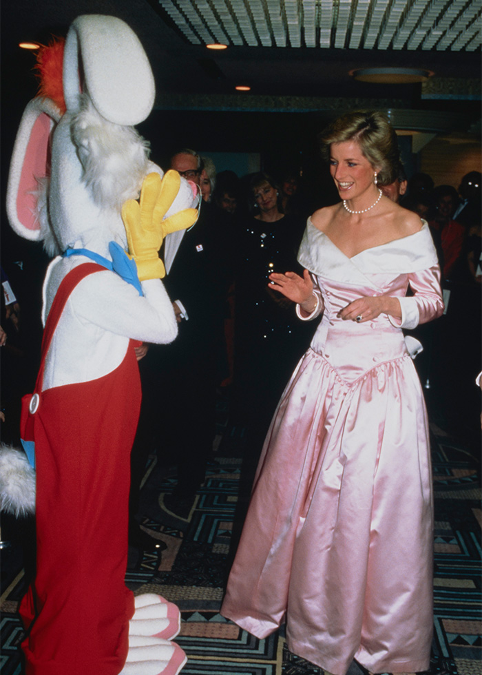 Princess Diana interacting with a character costume in a rarely-seen pop culture shot at a formal event.